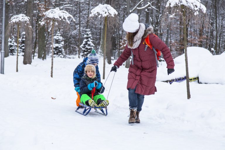 Winter family playing outdoor in the park.